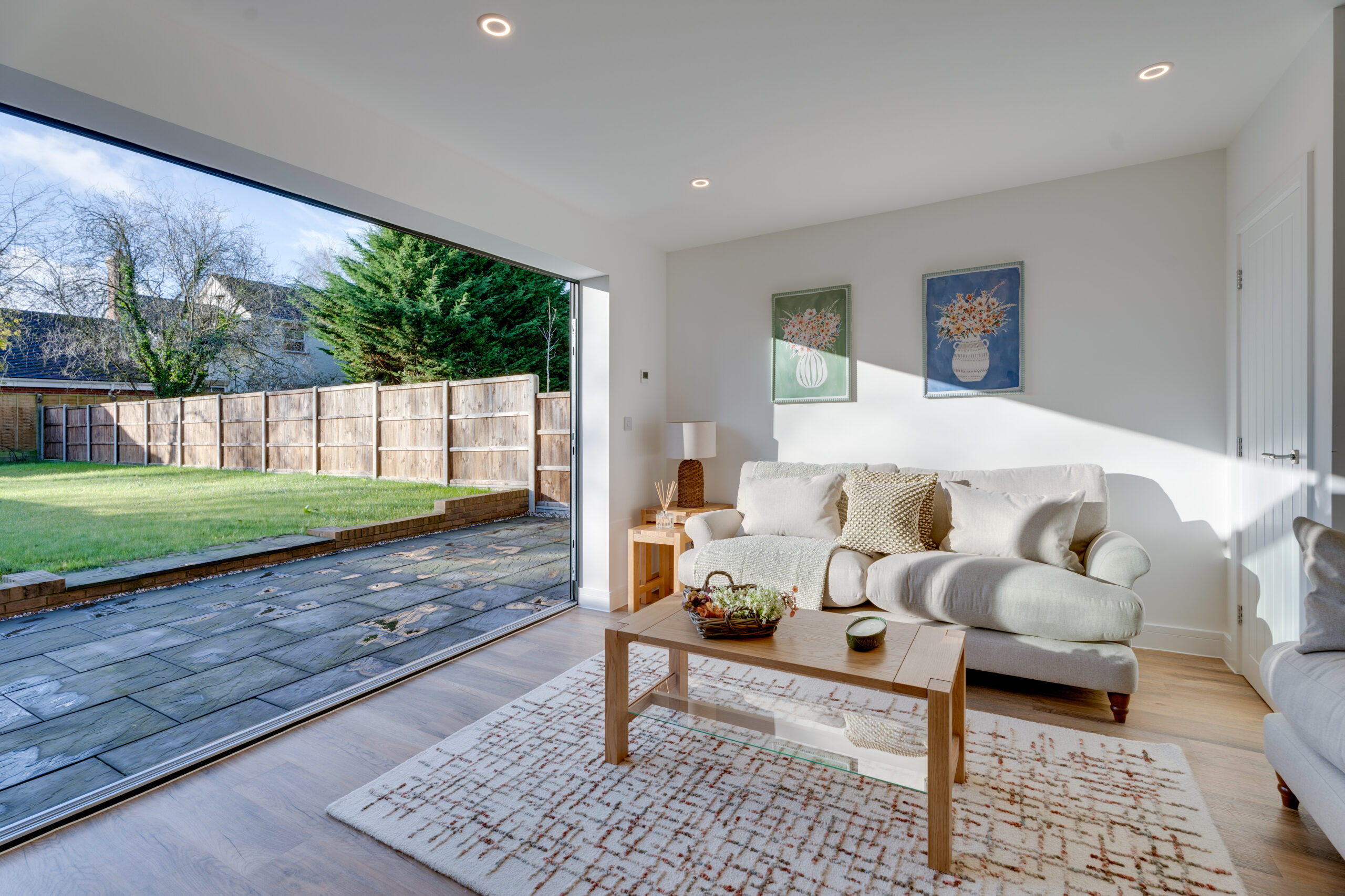 Freshwater Estates, a picture of a light, spacious room with a large sliding patio door. The room has two sofas and a coffee table with a rug underneath.