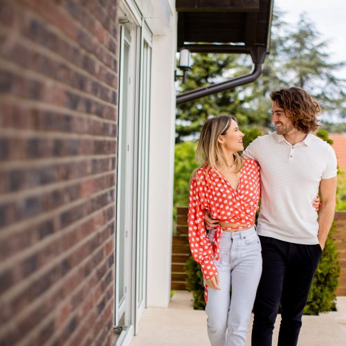 smiling-young-couple-in-love-walking-in-front-of-h-2025-02-21-19-32-14-utc-scaled